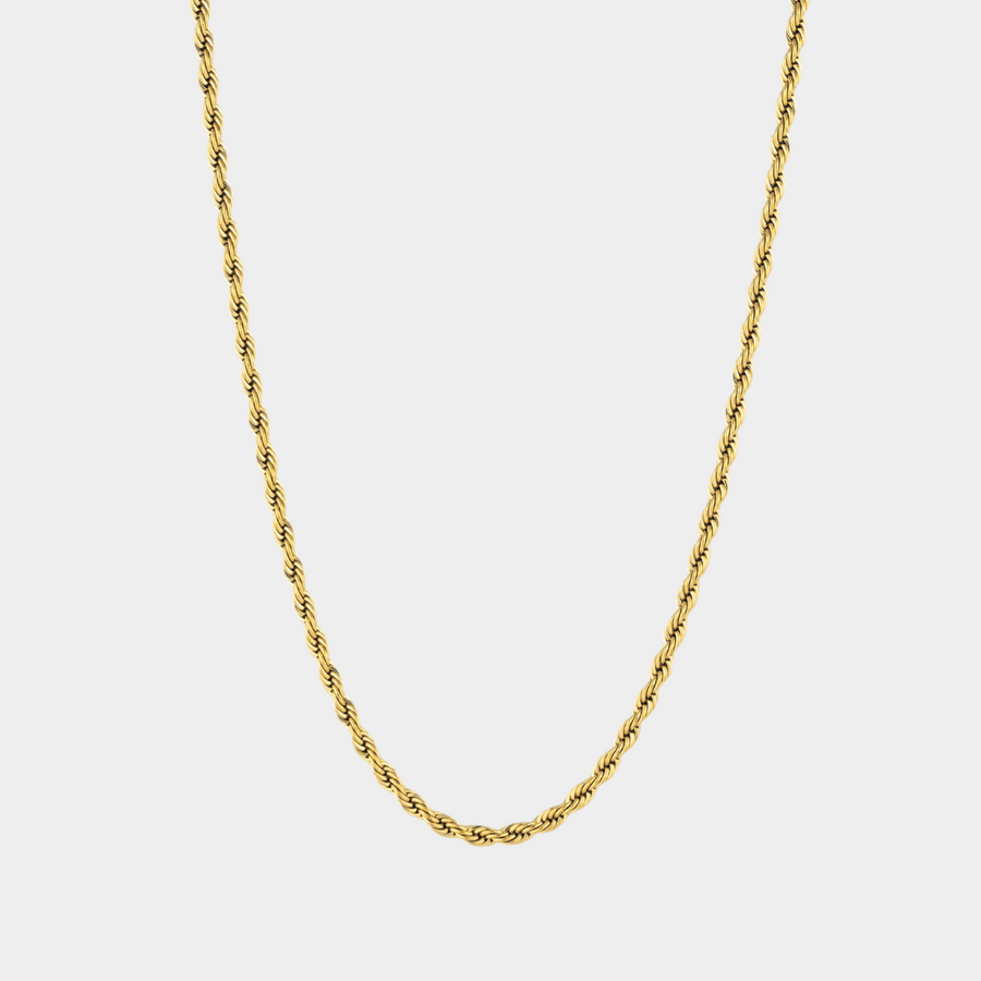 Gold chain necklace on a light gray background
