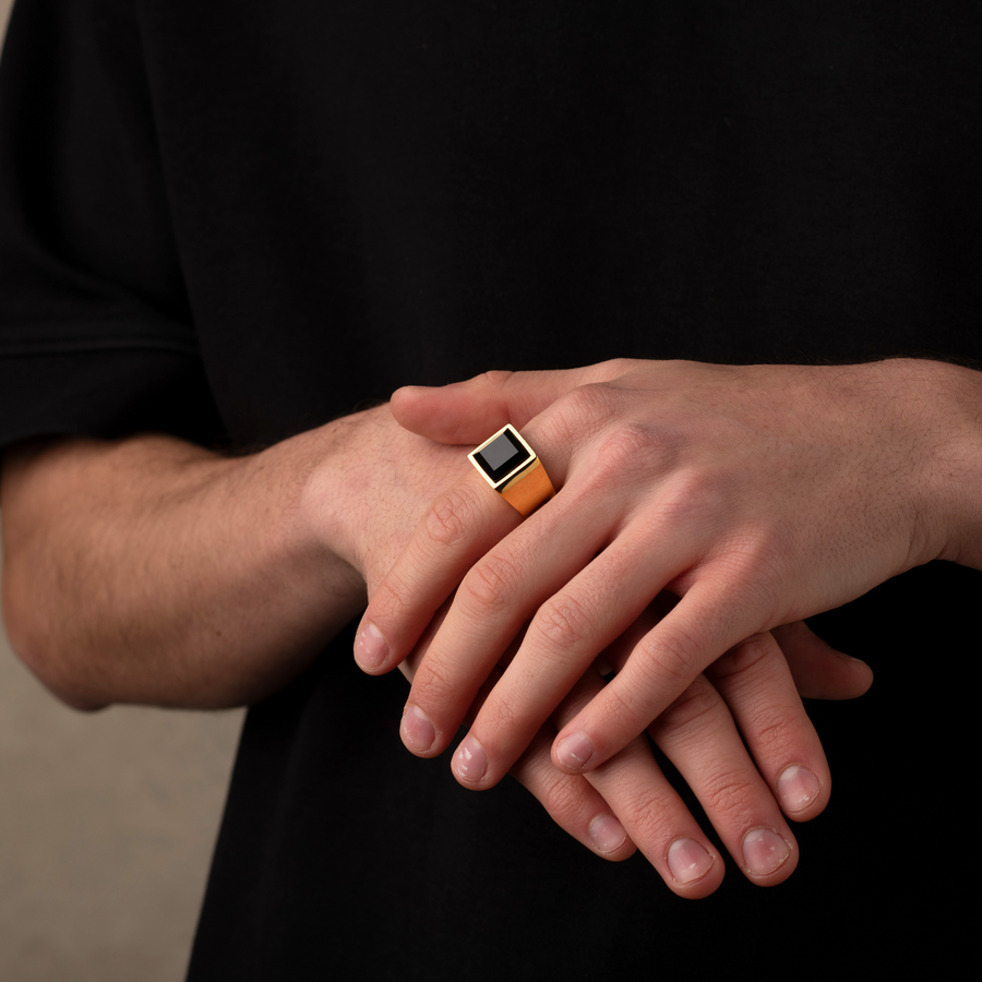 Close-up of hands with a ring on a black background