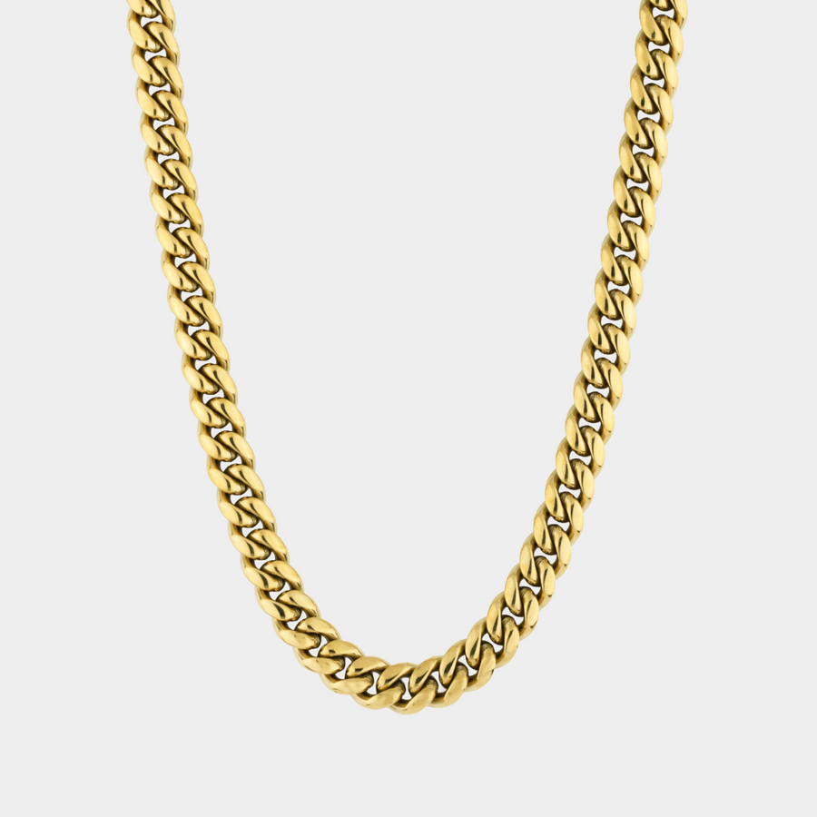 Gold chain necklace on a light gray background