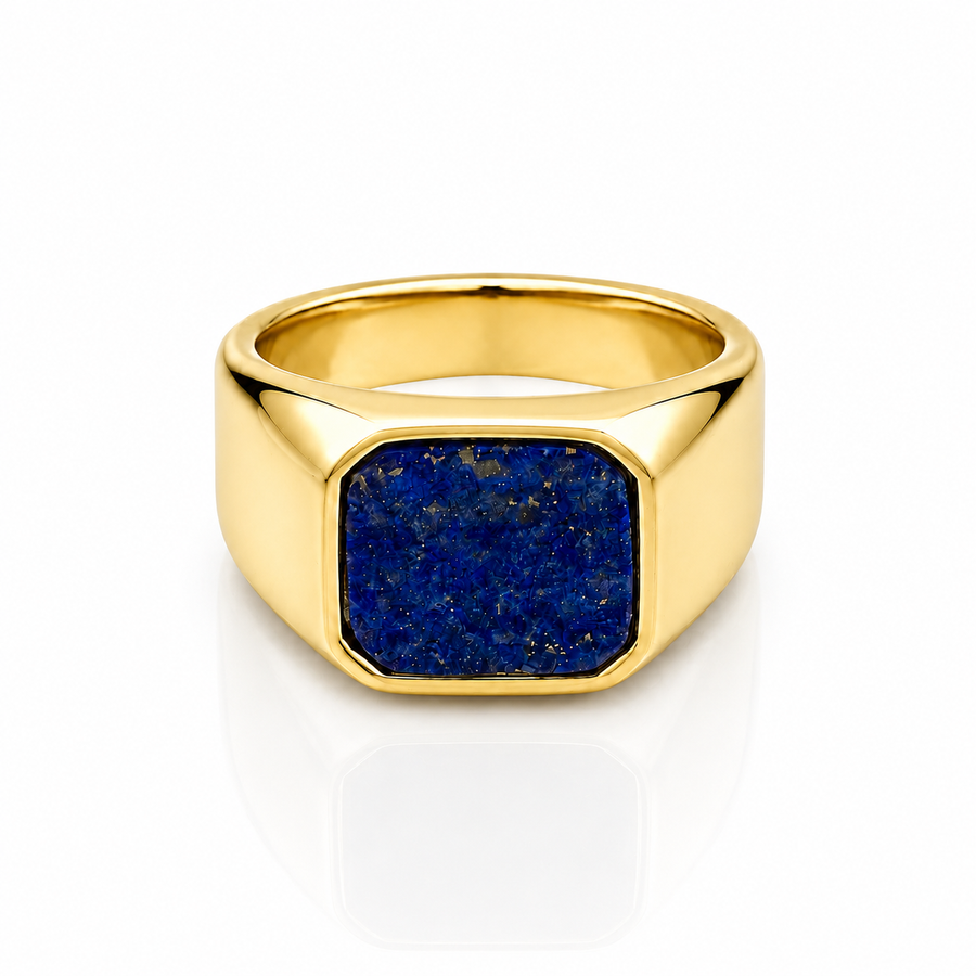 A gold signet ring featuring a square-cut dark blue lapis lazuli stone inlay, shown on a clean white background with a soft reflection.