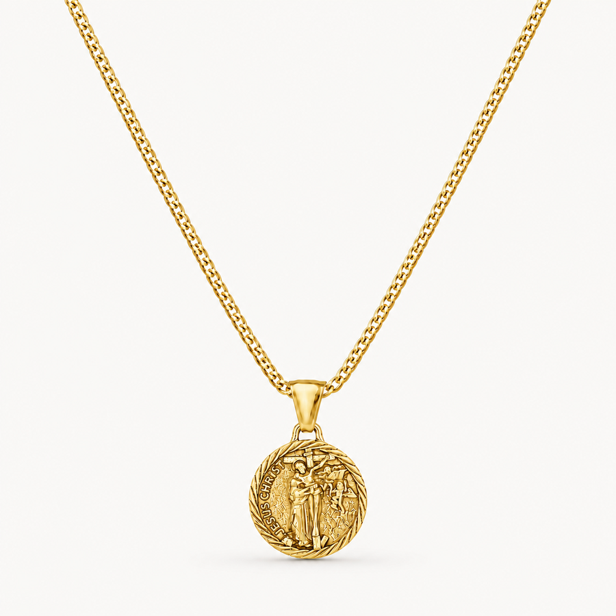 A gold chain necklace with a circular medallion pendant featuring an embossed figure, shown against a clean off-white background.