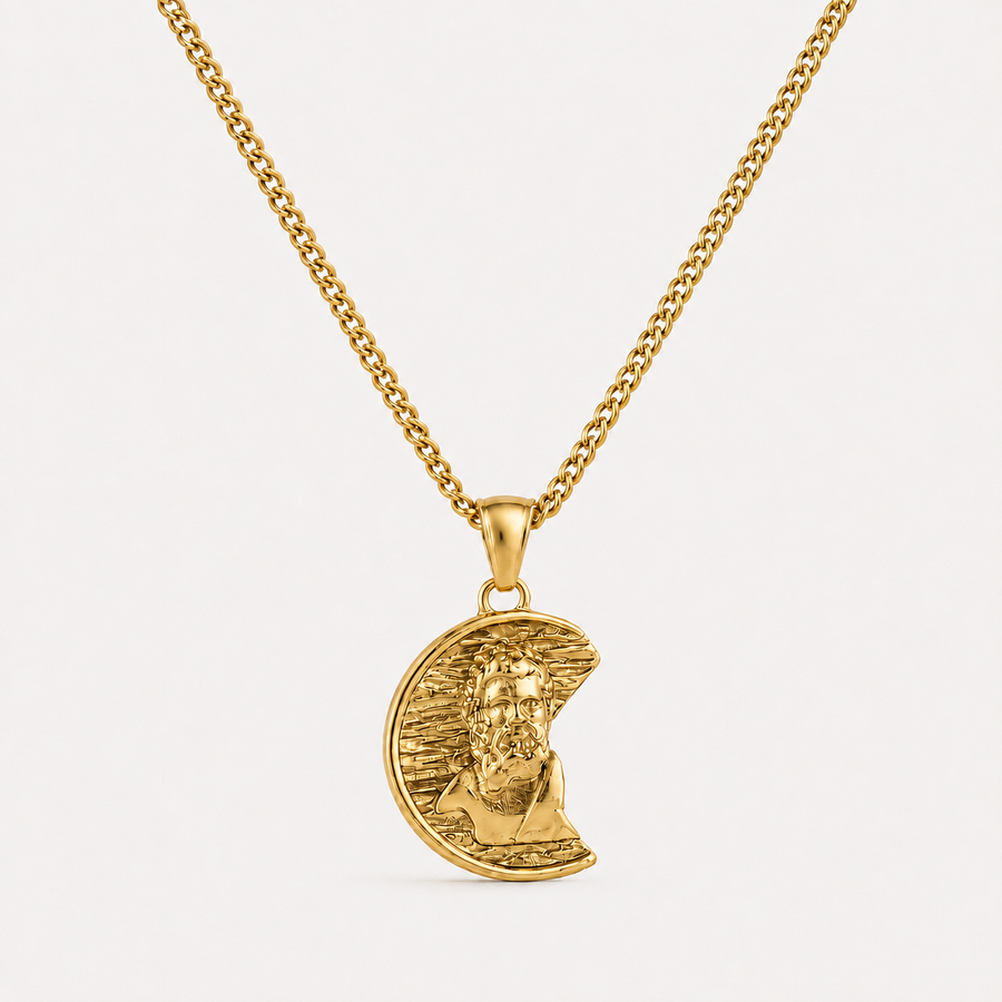 A gold pendant necklace featuring a crescent moon with a detailed portrait of Jesus Christ, suspended from a gold curb chain against a clean white background.