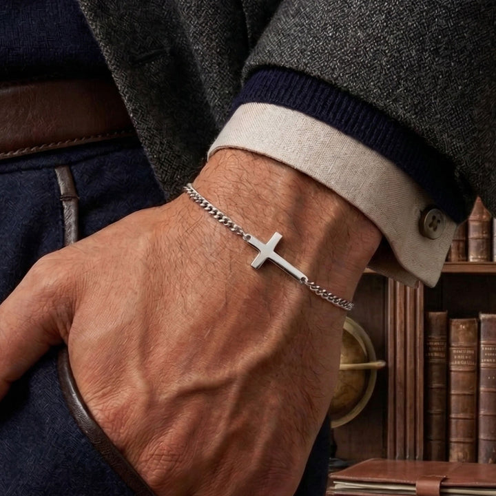 A close-up of a person's wrist wearing a silver cross-shaped bracelet.