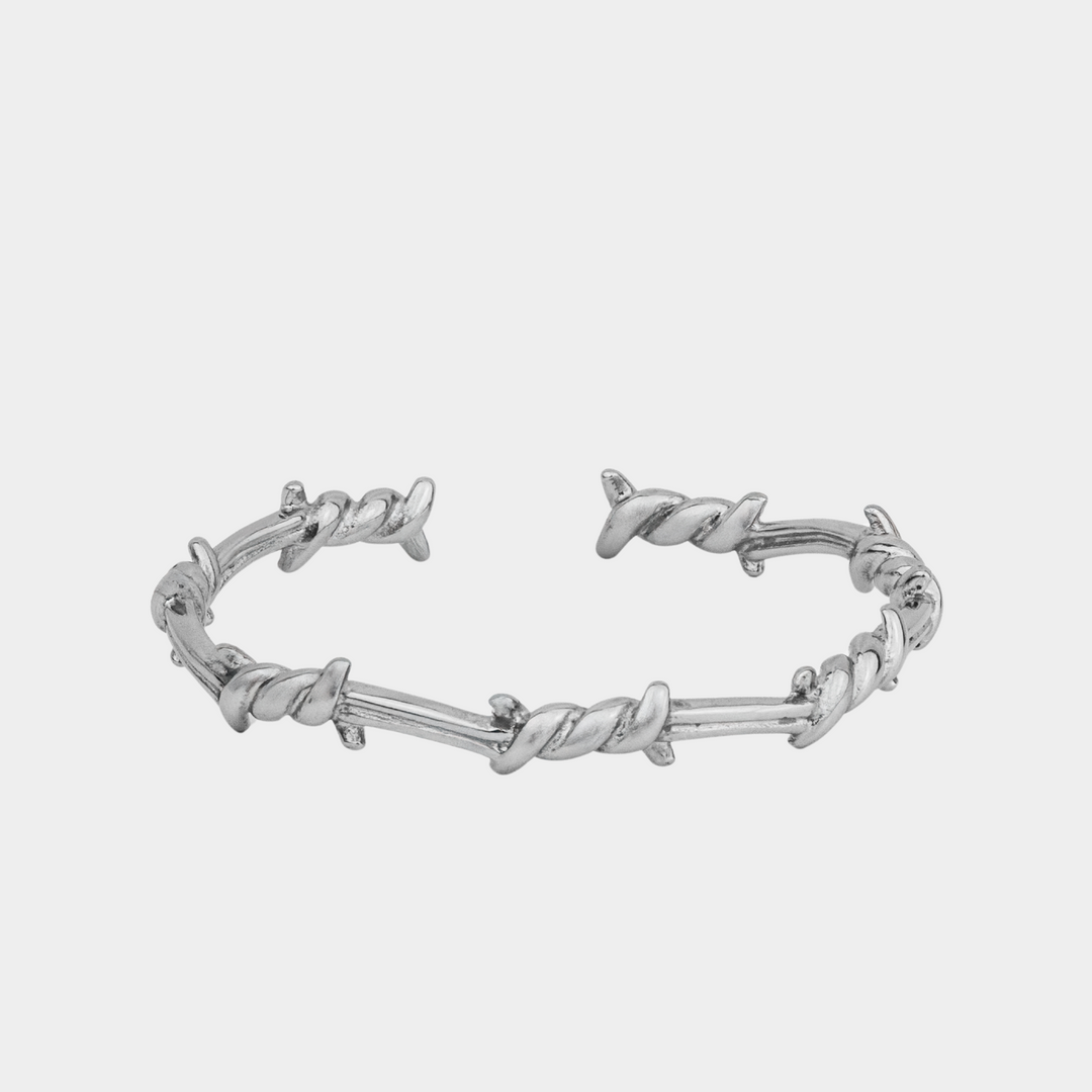 Silver barbed wire bracelet on a white background