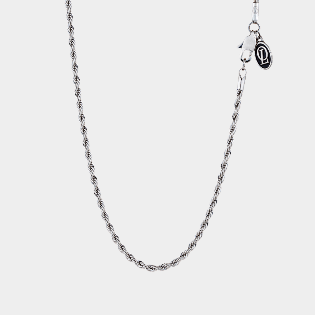 Silver chain necklace on a light gray background