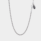 Silver chain necklace on a light gray background