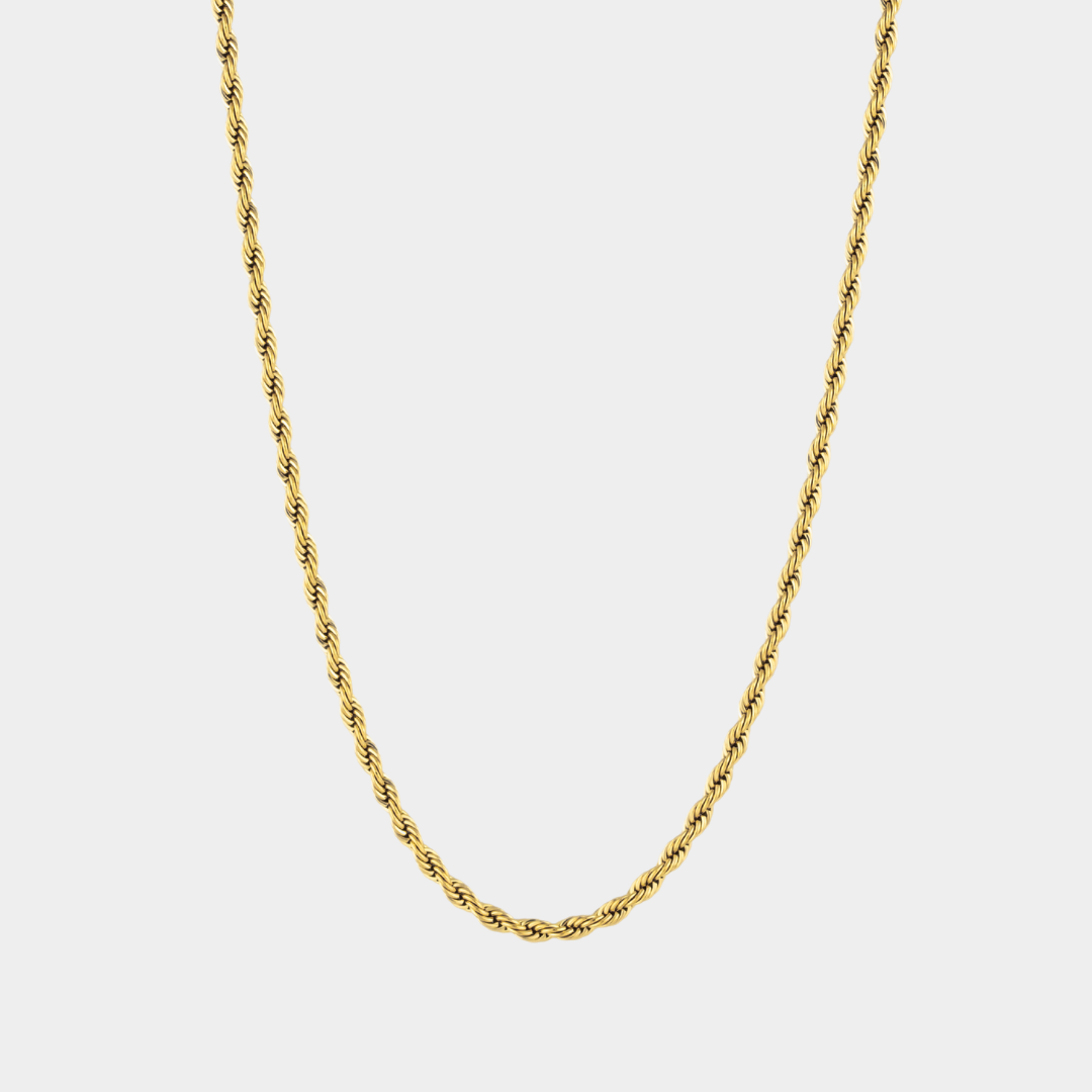 Gold chain necklace on a light gray background