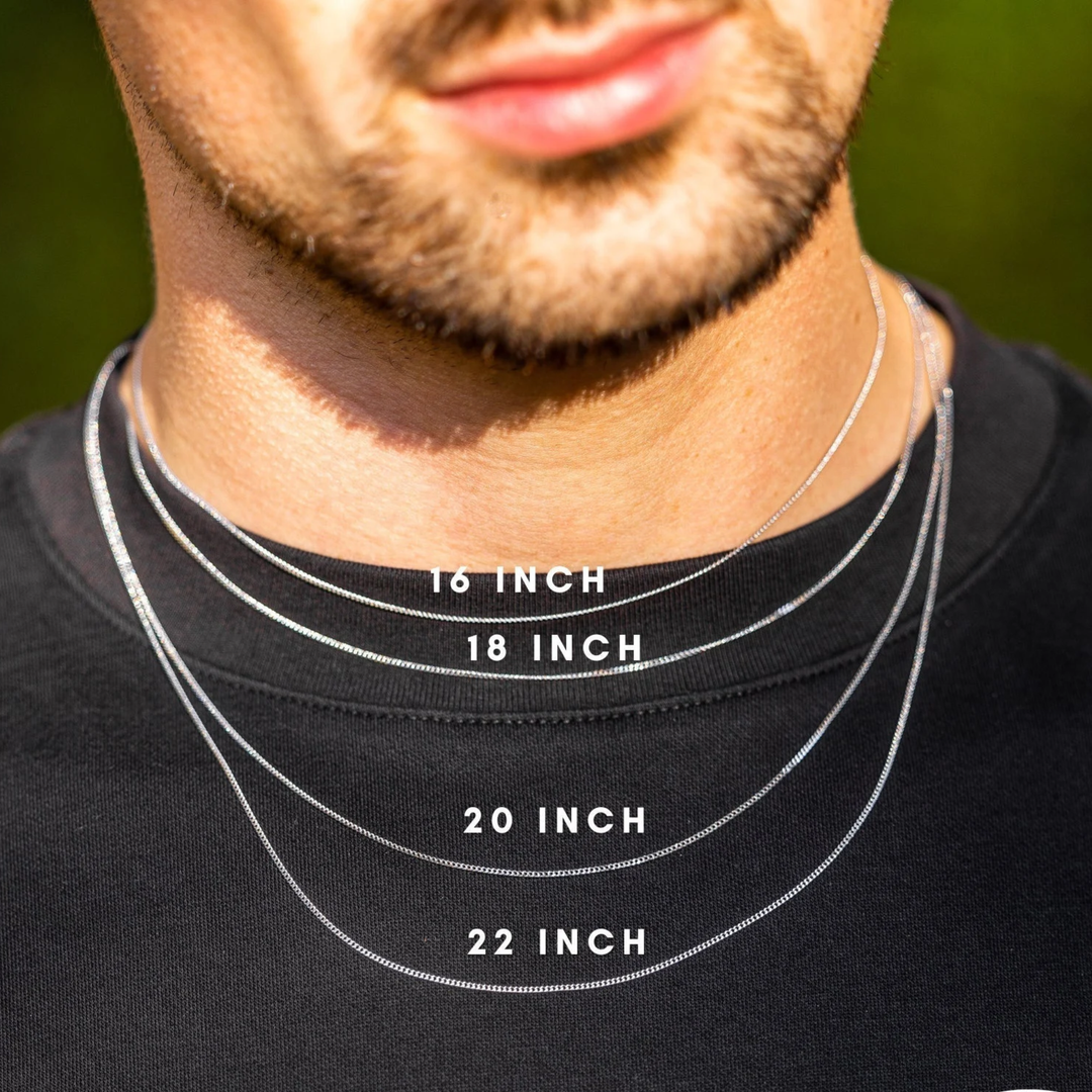 Man wearing necklaces of different lengths with labeled measurements on a black shirt.