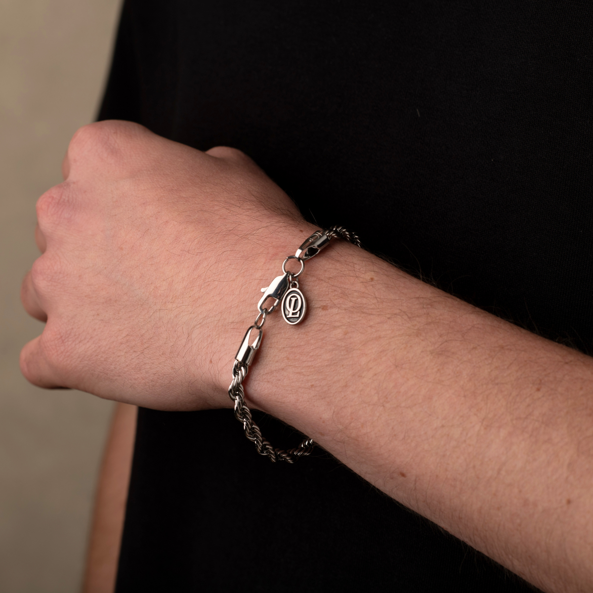 Silver bracelet on a wrist with a dark background
