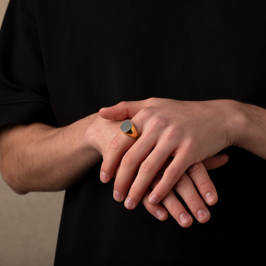 Close-up of two hands with a ring on a black background