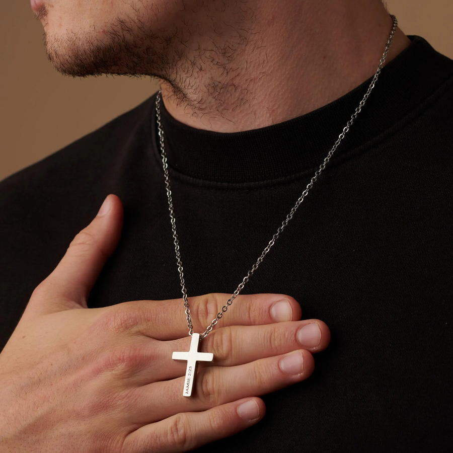 Man wearing a black shirt with a silver cross necklace