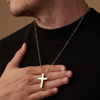 Man wearing a black shirt with a silver cross necklace