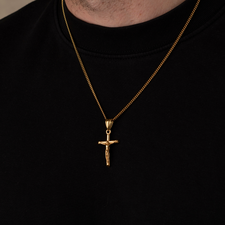 Gold necklace with a cross pendant on a black background