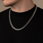 Silver chain necklace worn by a person on a plain background