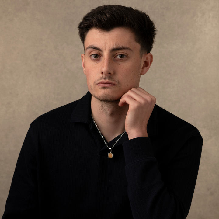 Man wearing a silver tiger eye stone necklace pendant