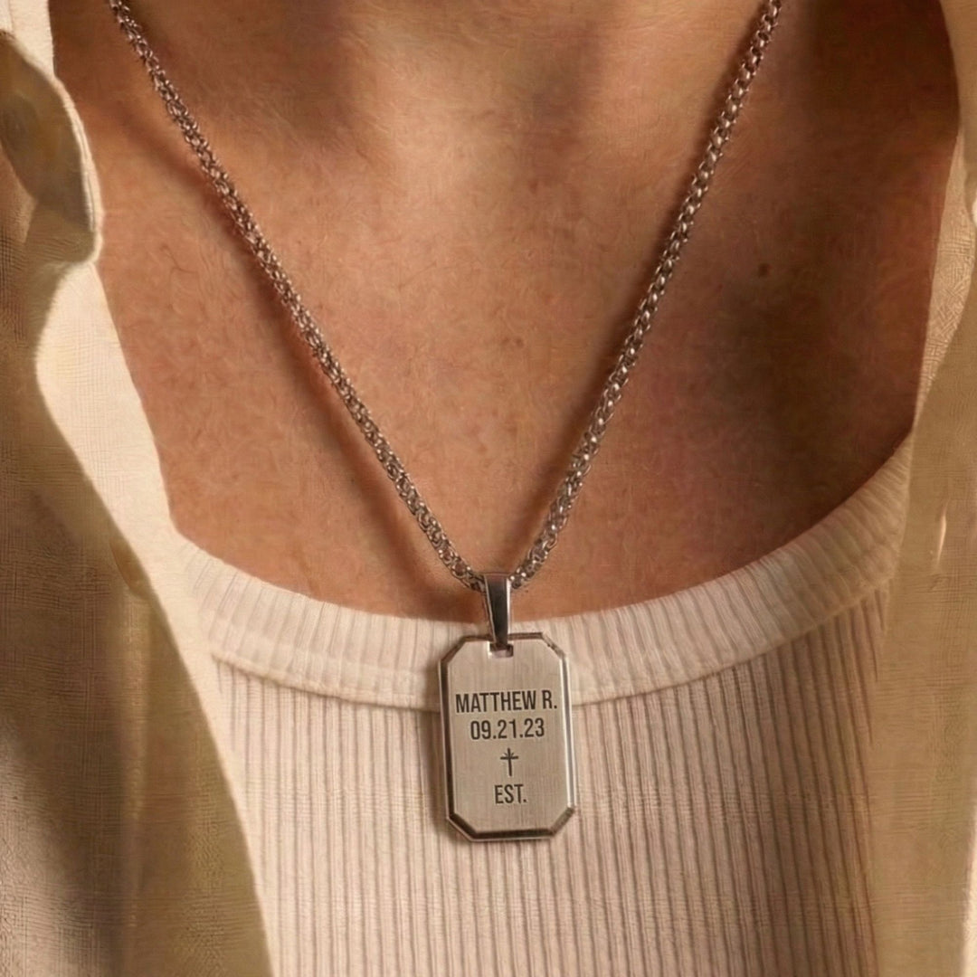 A silver necklace with a rectangular pendant that displays the name Matthew R. and the date 09.21.23 EST.
