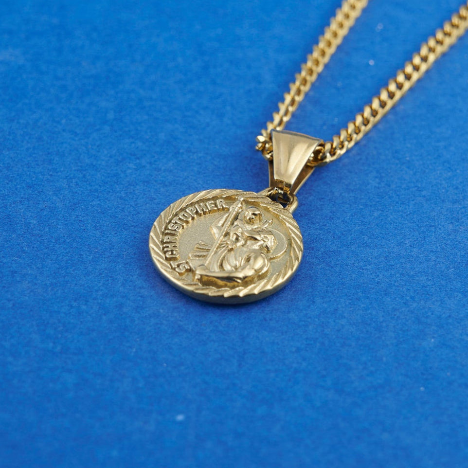 Gold necklace with a round pendant on a blue background
