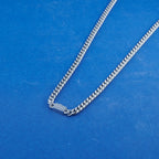 Silver chain necklace on a blue background