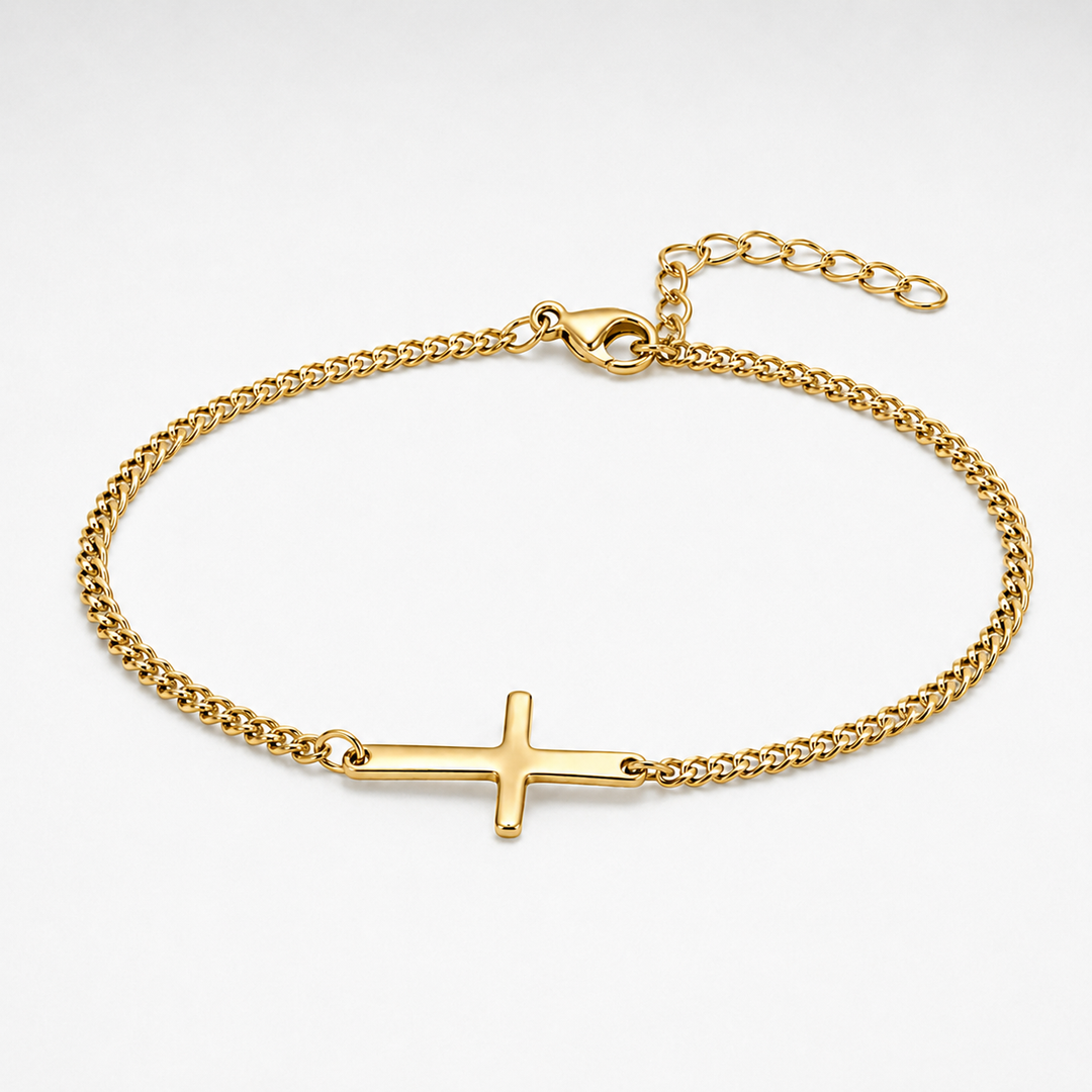 A gold chain bracelet with a polished cross charm, displayed on a clean white background.