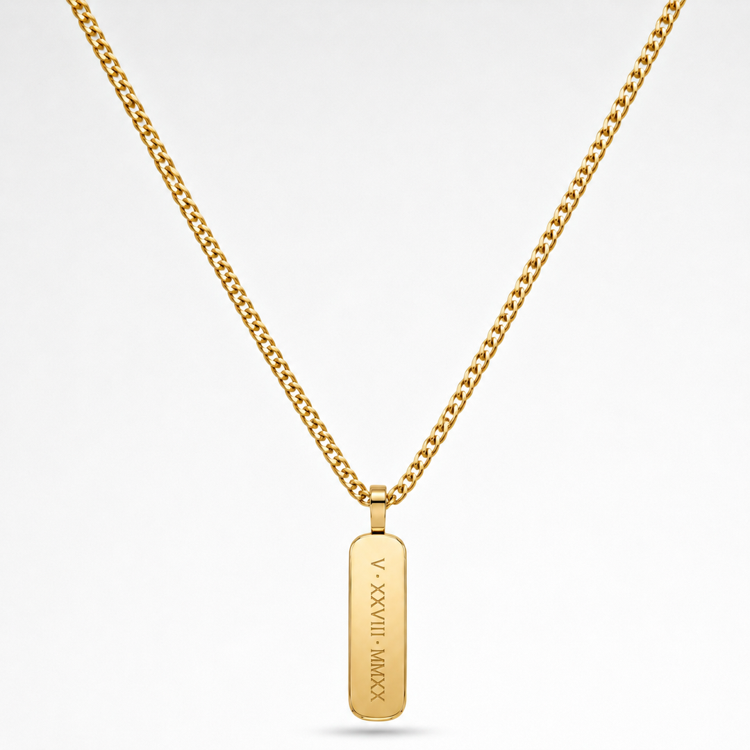 A gold chain necklace with a vertical rectangular gold pendant engraved with Roman numerals and a date, shown on a clean white background.