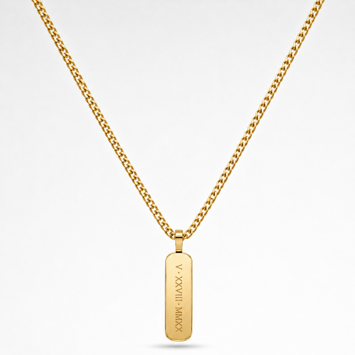 A gold chain necklace with a vertical rectangular gold pendant engraved with Roman numerals and a date, shown on a clean white background.