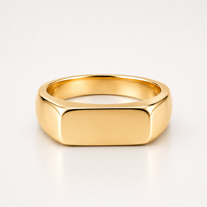 A polished yellow gold signet ring with a flat, rectangular face and rounded shoulders, shown on a clean white background.