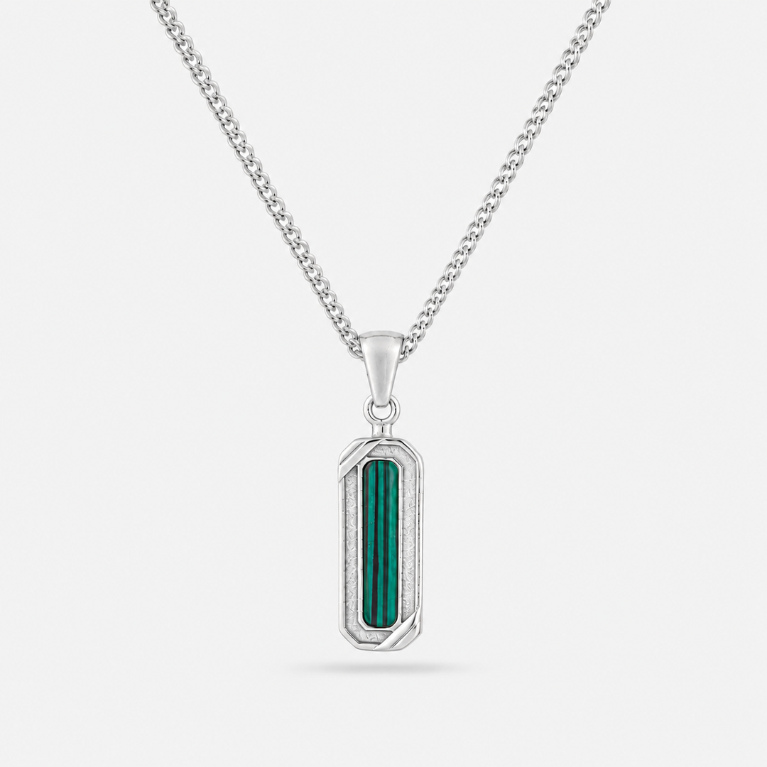 Silver pendant with green stone on a white background