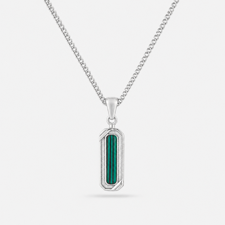Silver pendant with green stone on a white background