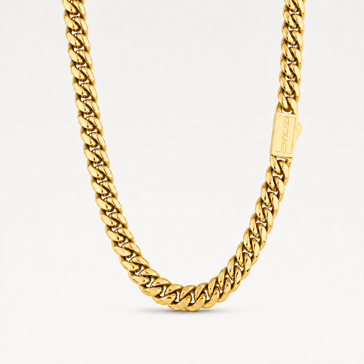 A close-up of a gold Cuban link chain necklace with a rectangular branded tag, photographed against a clean white background.