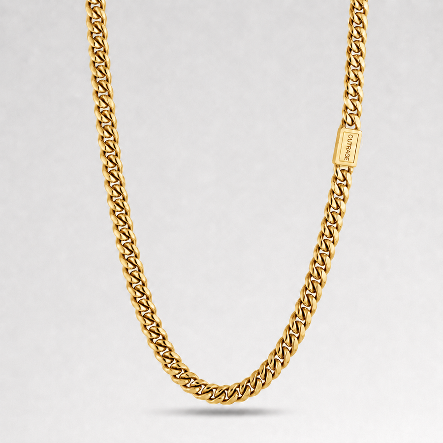 A gold-toned Cuban link chain necklace with a rectangular branded clasp, photographed against a clean light gray studio background.