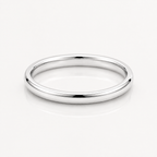 A minimalist, polished silver band ring with a smooth, rounded profile, displayed on a clean white reflective surface.
