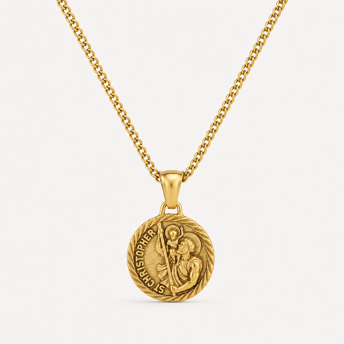 A gold pendant necklace featuring a circular Saint Christopher medal on a matching chain, set against a clean off-white background.