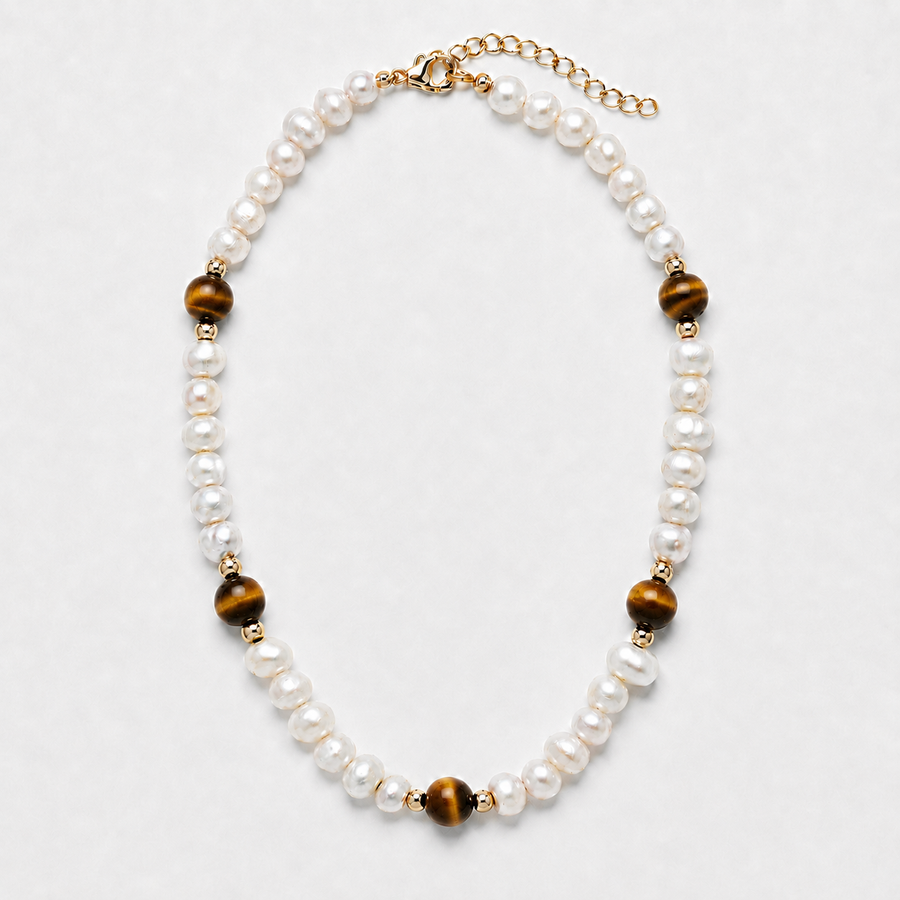 A pearl and tiger's eye bead necklace with gold-toned metal accents, displayed on a light gray background.