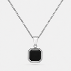 A silver-toned chain necklace with a geometric octagonal pendant featuring a black inlay, set against a light gray background.