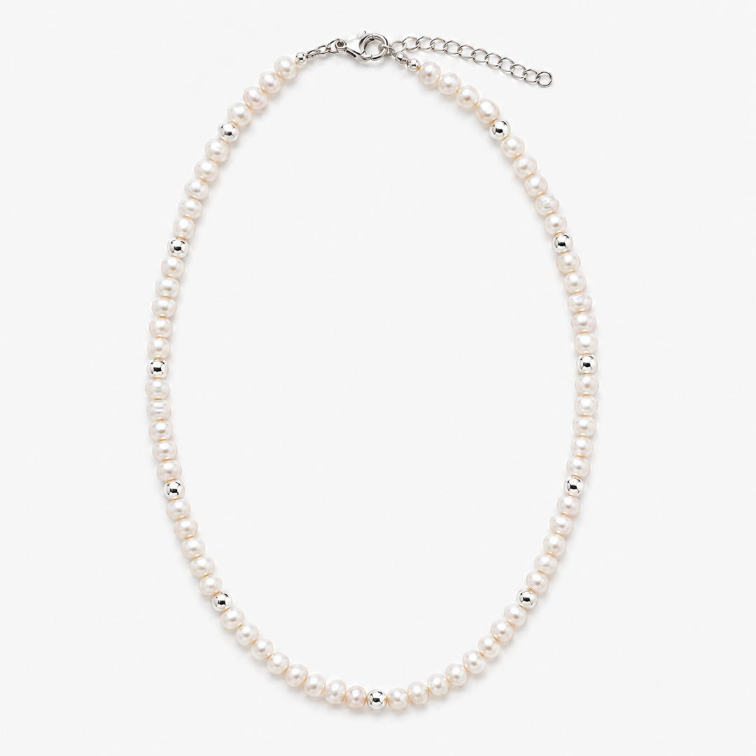 A classic pearl necklace with small white pearls and silver spacer beads, featuring a silver clasp and extender chain, shown on a light gray background.