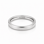 A minimalist, polished silver band ring with the word 'OUTRAGE' engraved inside, shown on a clean white background with a soft reflection.