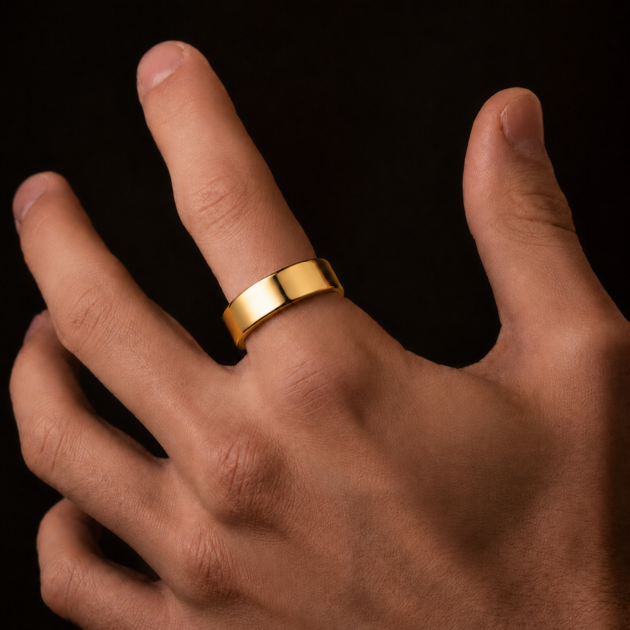 A polished yellow gold band ring worn on a person's ring finger, shown in a close-up shot against a solid black background.