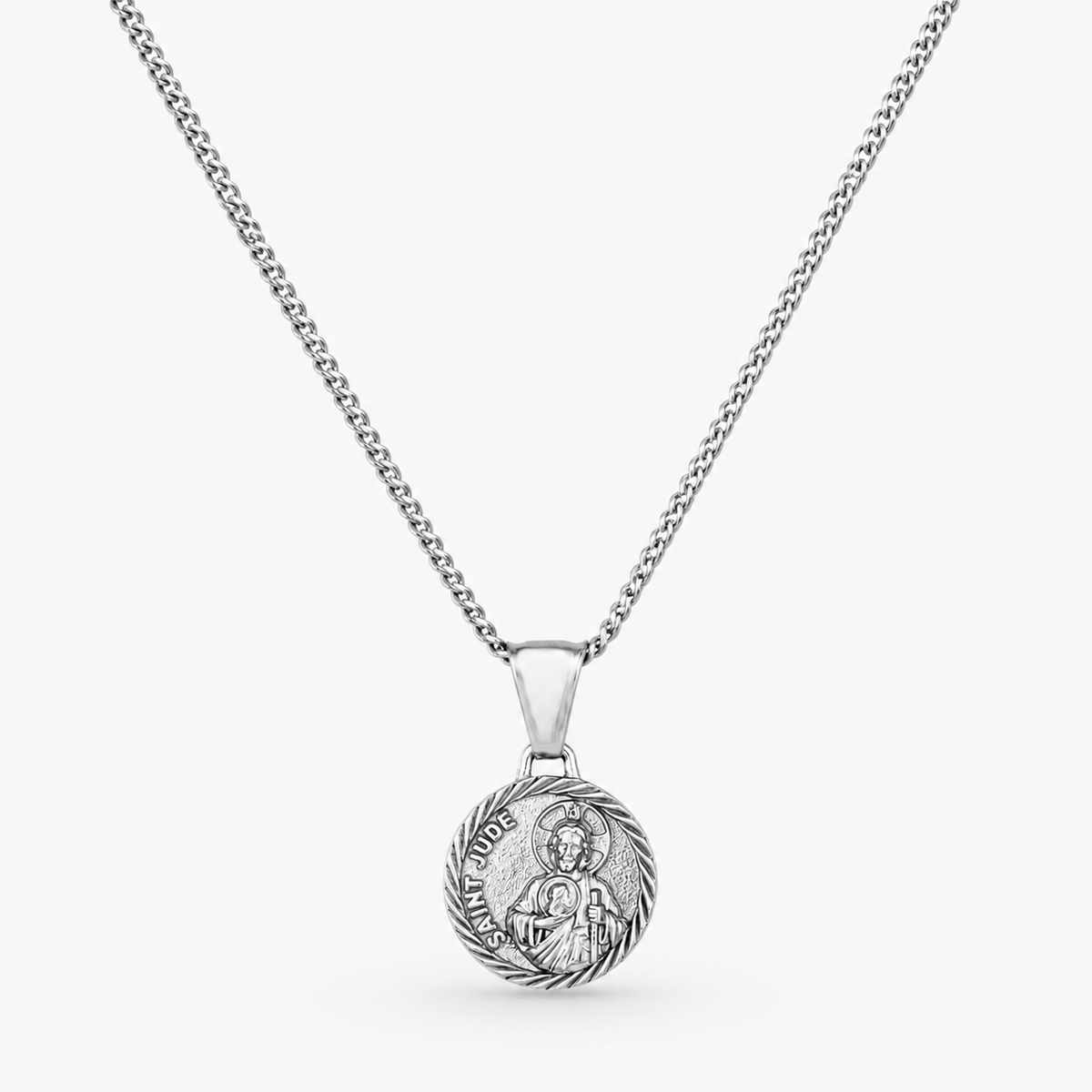 A silver chain necklace with a round, detailed religious pendant, shown against a light gray background.