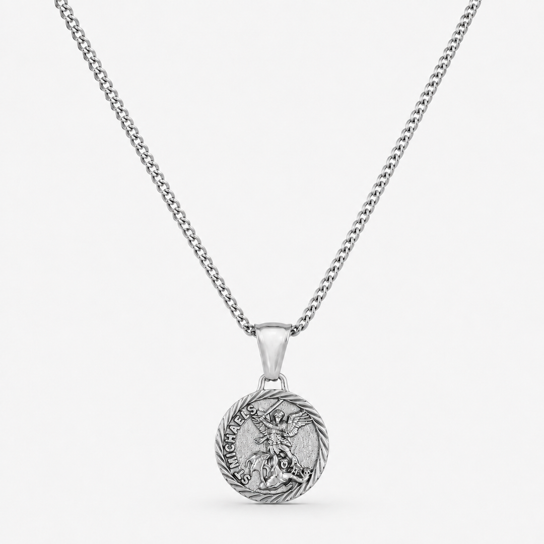 A silver-toned chain necklace with a round pendant featuring a detailed dragon design and the words 'HARD AS A BONE' on a light gray background.