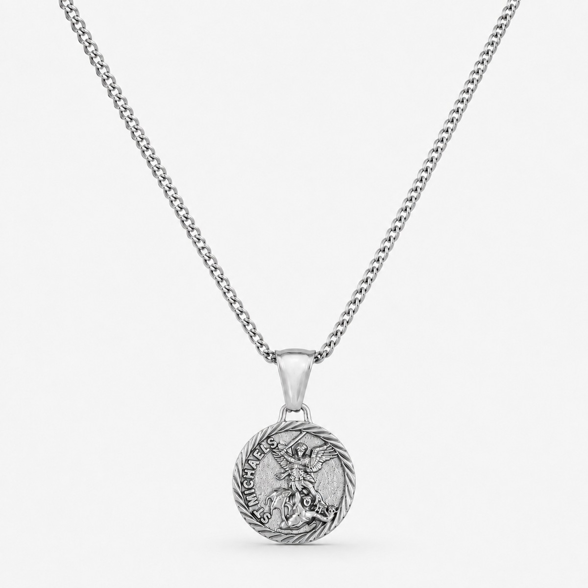 A silver-toned chain necklace with a round pendant featuring a detailed dragon design and the words 'HARD AS A BONE' on a light gray background.