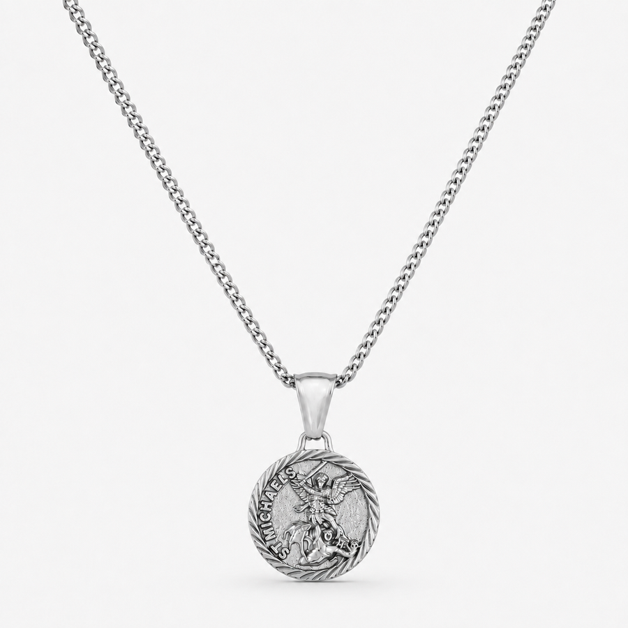 A silver-toned chain necklace with a round pendant featuring a detailed dragon design and the words 'HARD AS A BONE' on a light gray background.