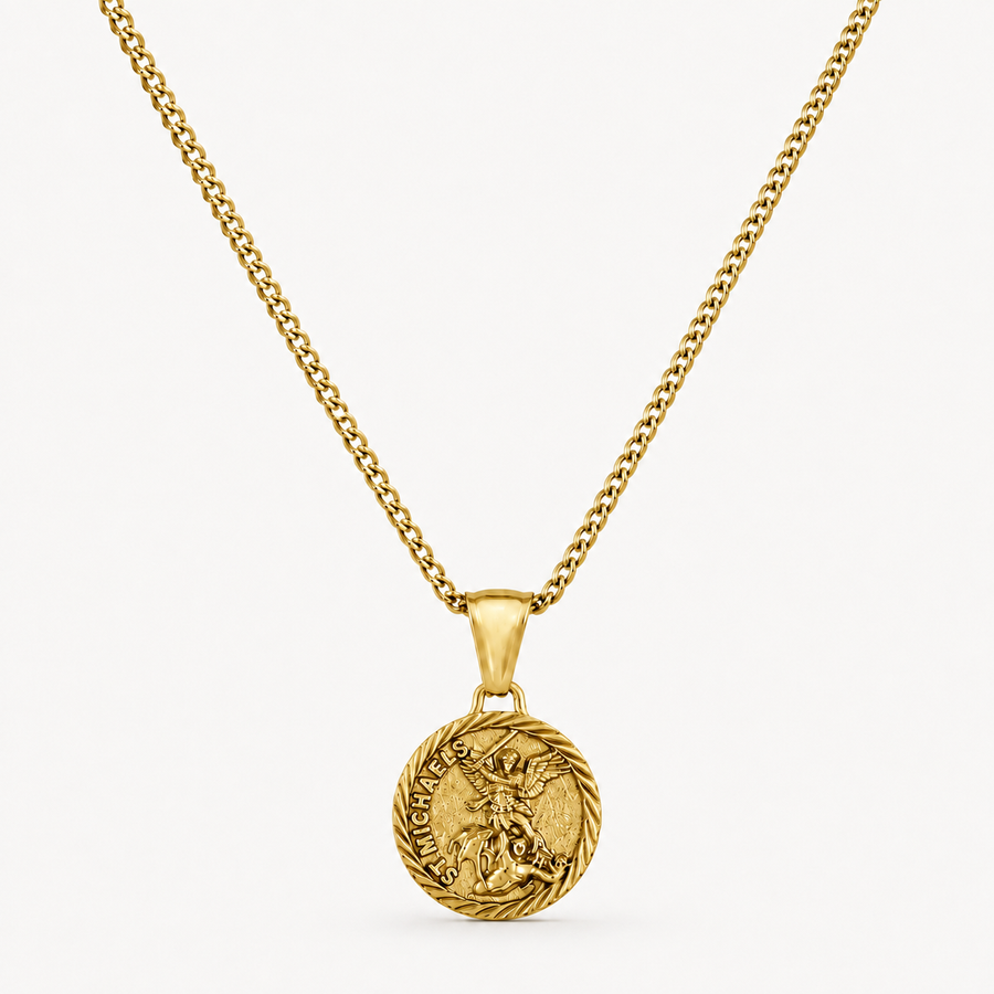 A gold chain necklace with a round medallion pendant featuring a detailed figure and engraved text, displayed against a clean off-white background.