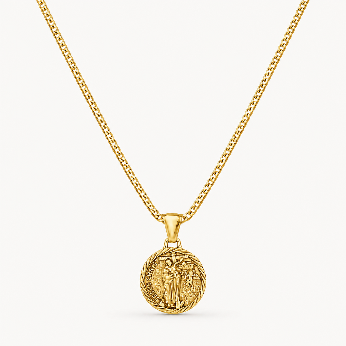 A gold chain necklace with a circular medallion pendant featuring an embossed figure, shown against a clean off-white background.