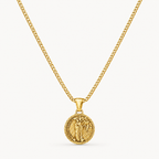 A gold chain necklace with a circular medallion pendant featuring an embossed figure, shown against a clean off-white background.