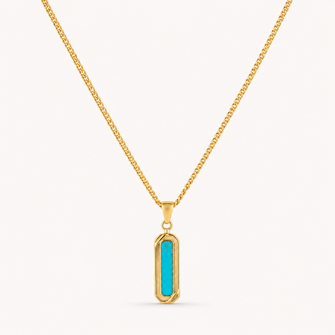 A gold chain necklace with a vertical bar pendant featuring a bright turquoise center, set against a plain off-white background.