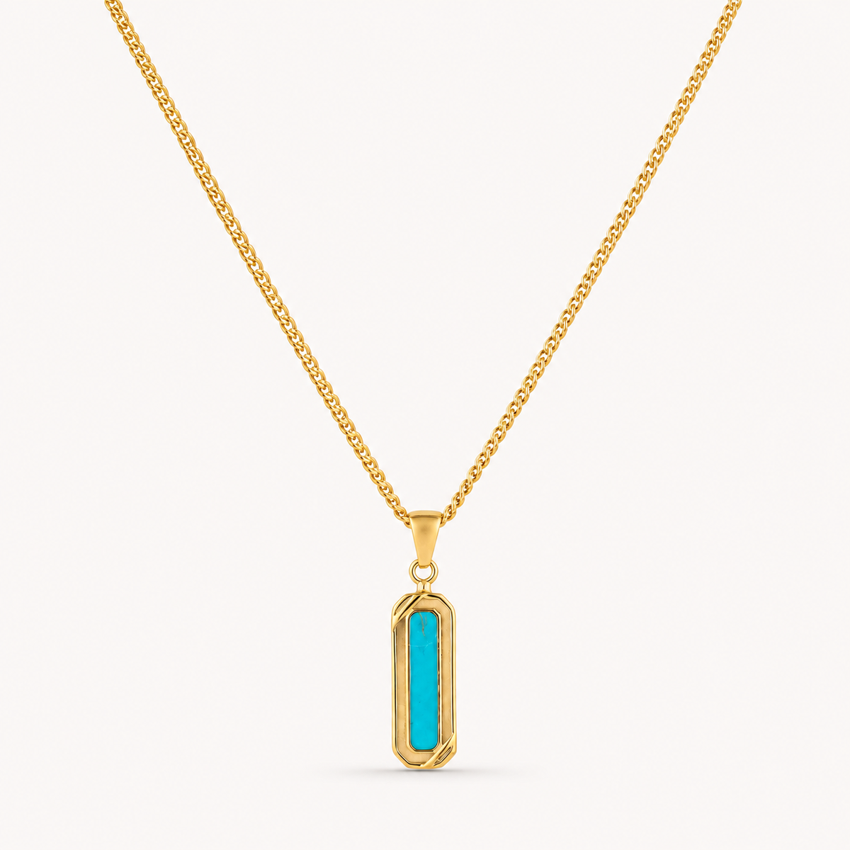 A gold chain necklace with a vertical bar pendant featuring a bright turquoise center, set against a plain off-white background.
