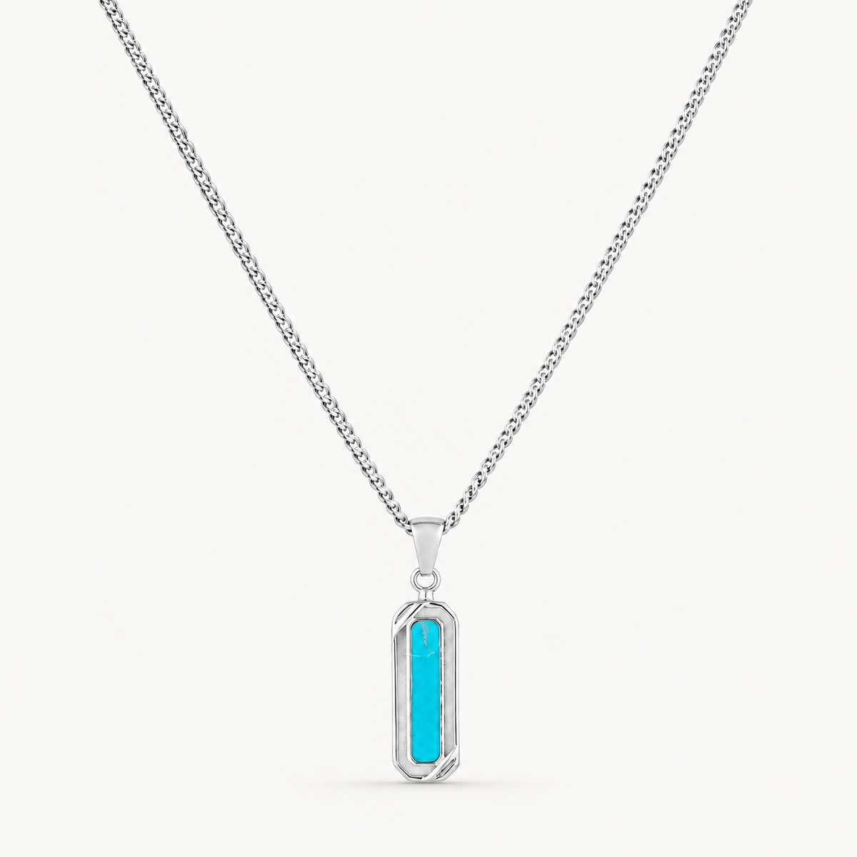 A silver-toned chain necklace with a vertical rectangular pendant featuring a bright turquoise blue center, shown on a clean off-white background.