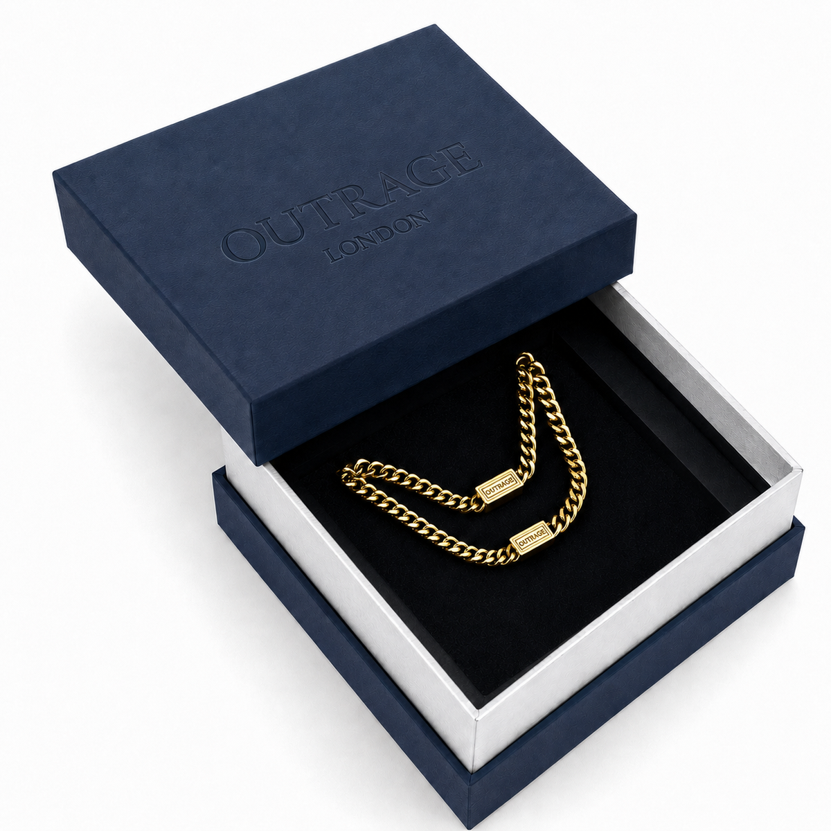 A gold chain necklace with a clasp is displayed inside an open navy blue and white jewelry box. The embossed brand name 'OUTRAGE LONDON' is visible on the navy lid.