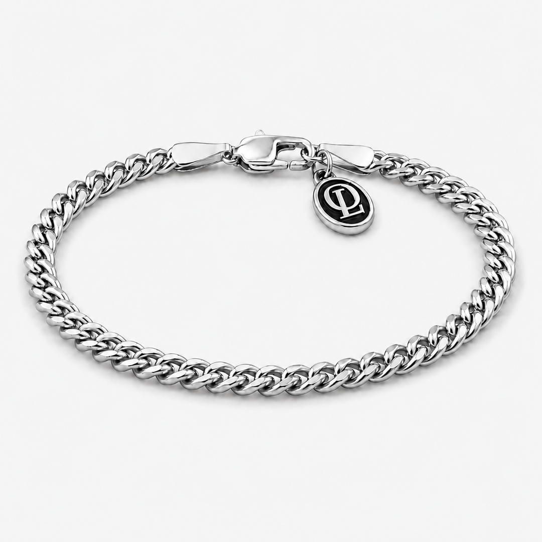 A silver-toned curb link chain bracelet with a spring-ring clasp and a small oval charm featuring an interlocking 'P' logo, shown on a light gray background.