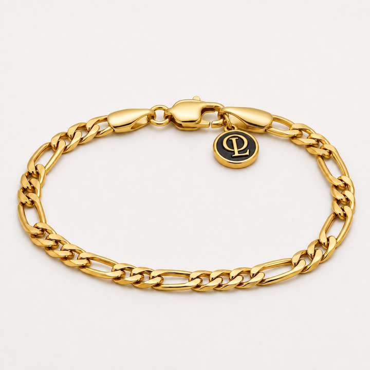 A gold-toned metal chain bracelet with a lobster clasp and a small round black-and-gold logo charm, photographed on a clean white background.
